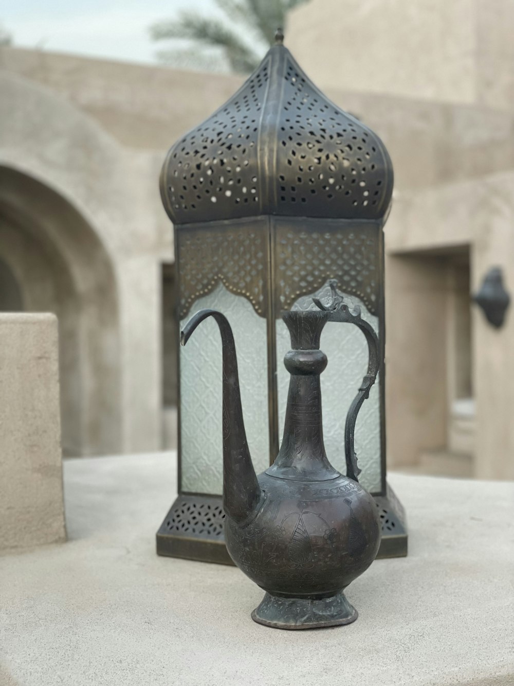 a large metal vase sitting on top of a cement slab