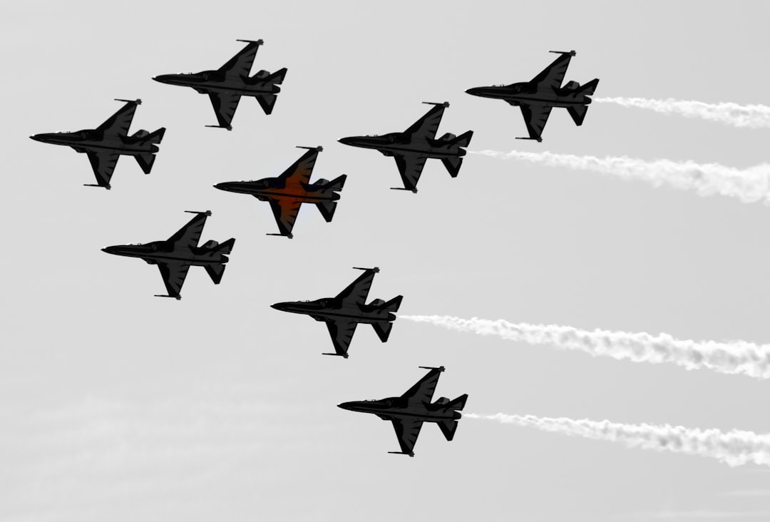 a group of fighter jets flying through a cloudy sky