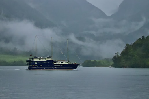 A mysterious pirate ship sailing through foggy waters, with a treasure chest visible on the deck.