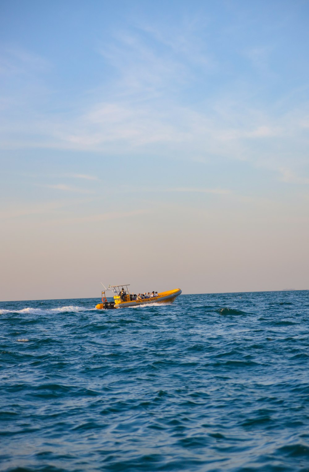 a yellow boat in the middle of the ocean
