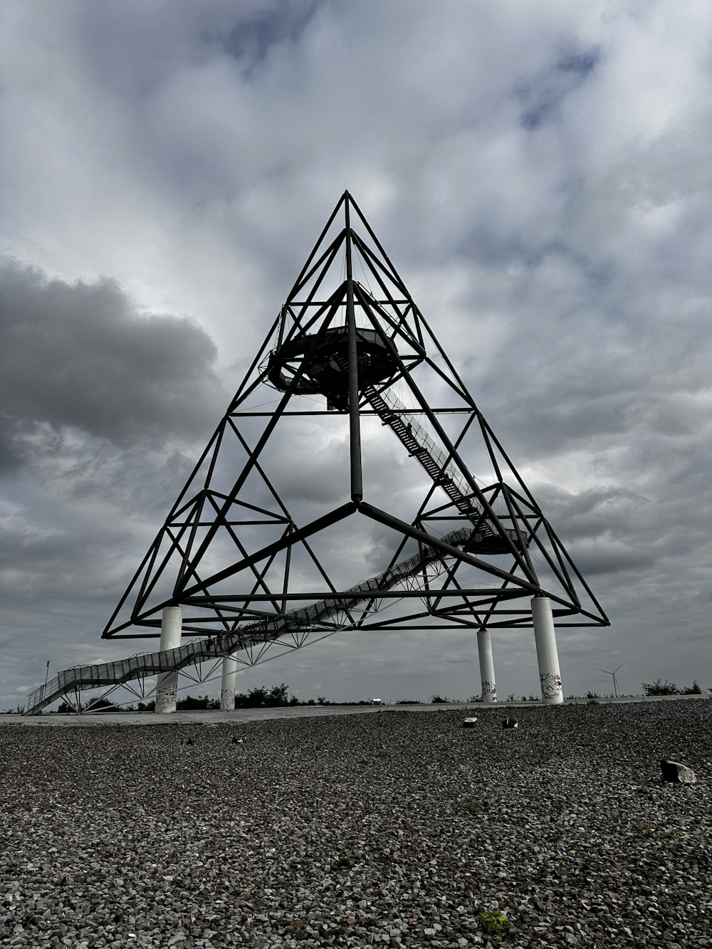 a large metal structure sitting on top of a rocky beach