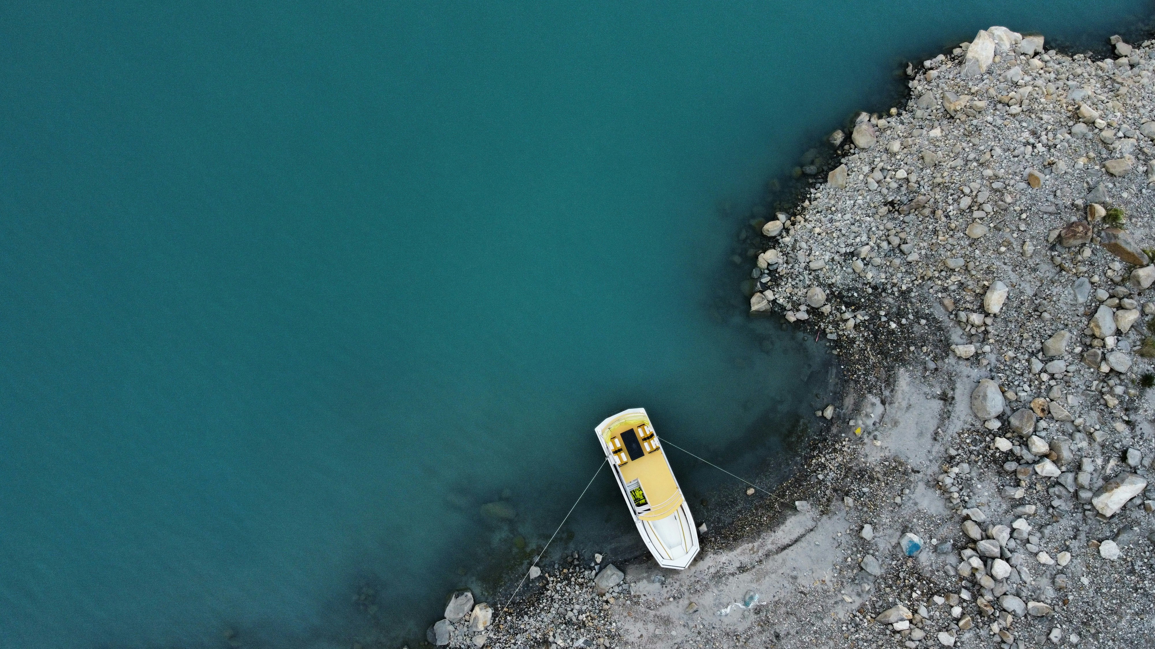 um pequeno barco sentado em cima de uma praia rochosa