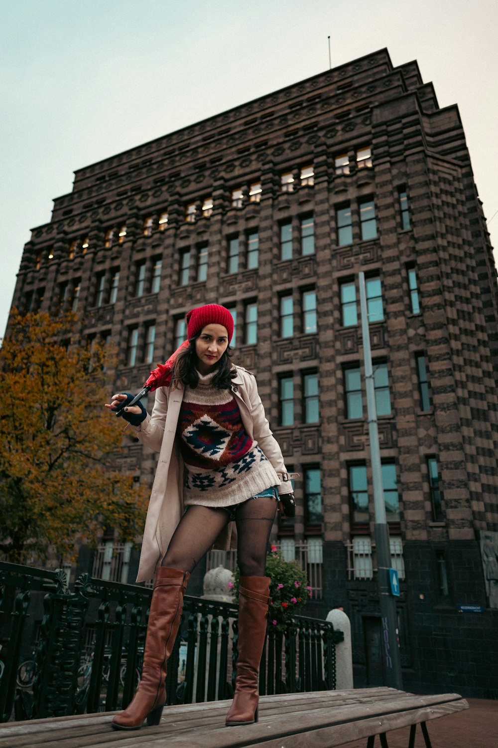 a woman standing on a platform in front of a tall building