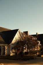 Photo of a classic Connecticut three-family residential building bathed in warm afternoon light.