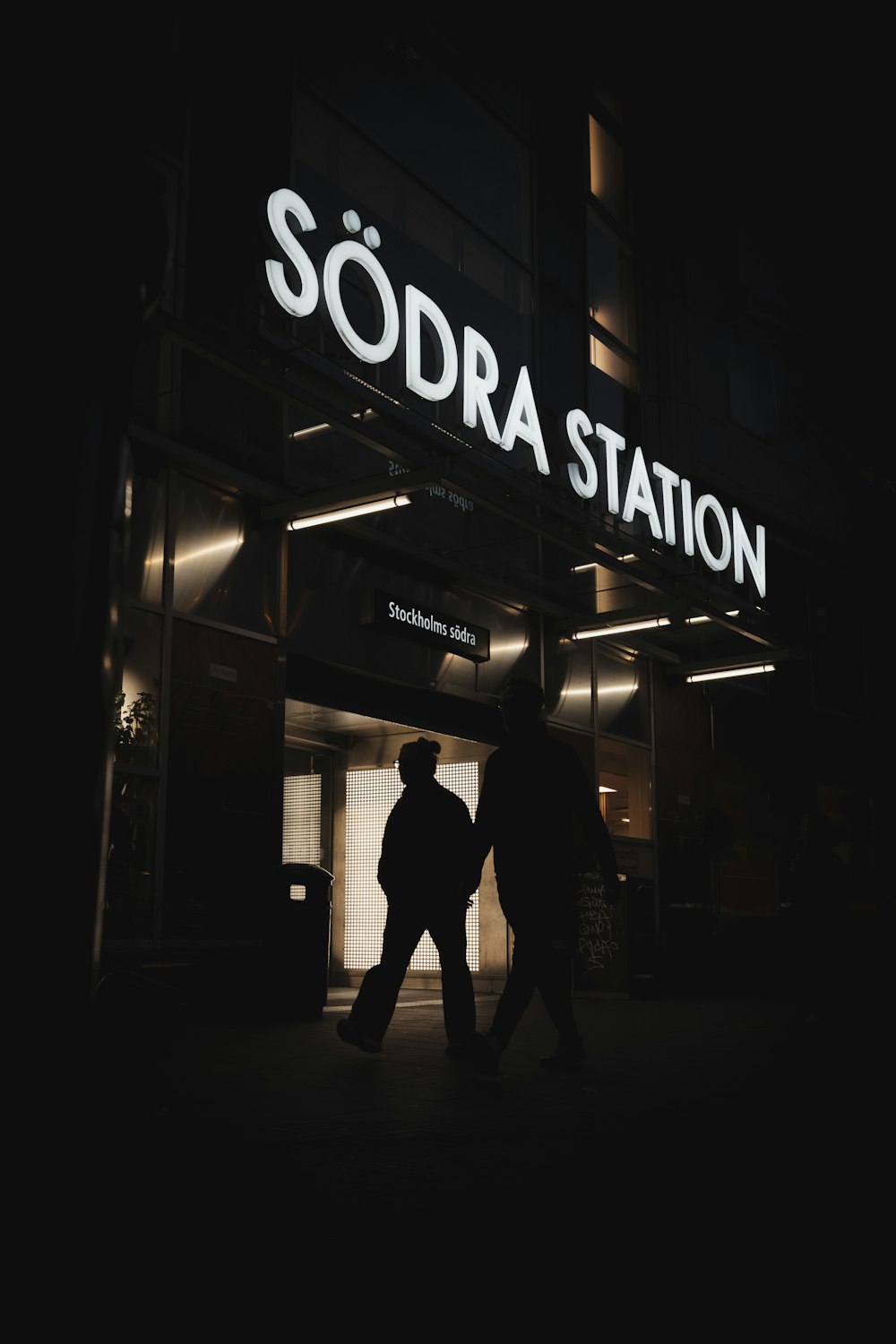 a couple of people that are walking in front of a building