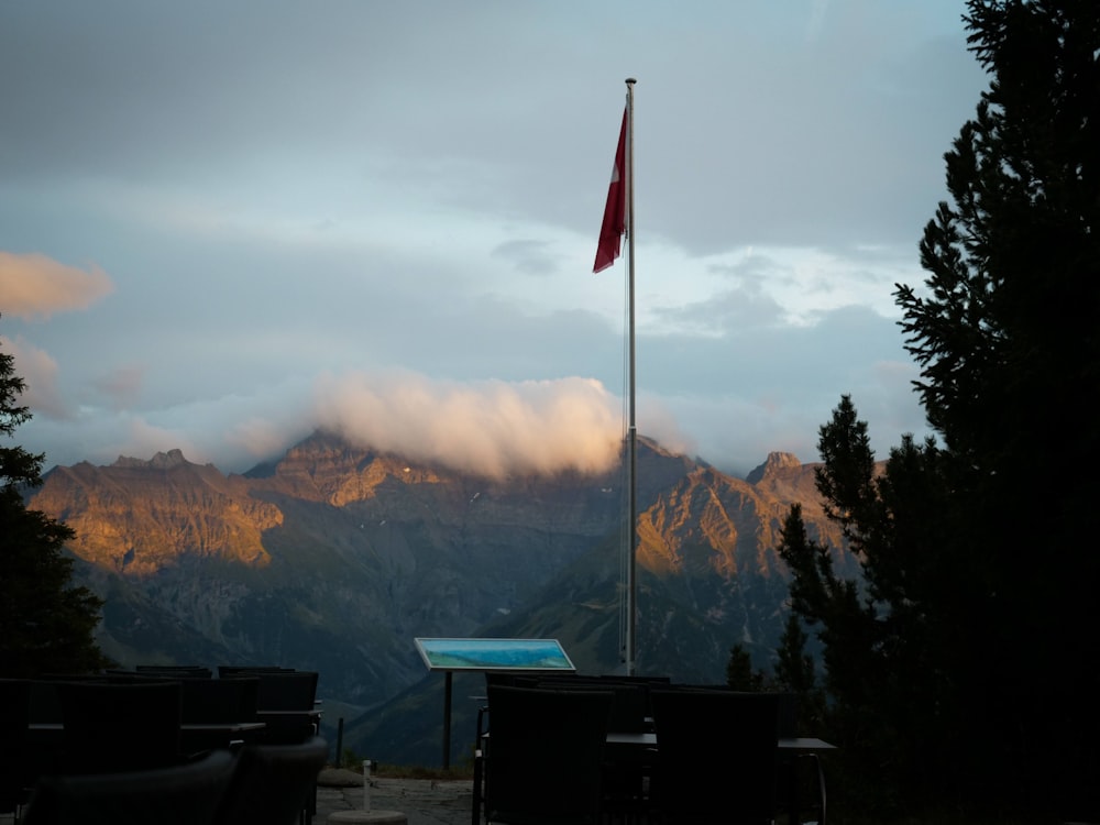 a flag on top of a flagpole with mountains in the background