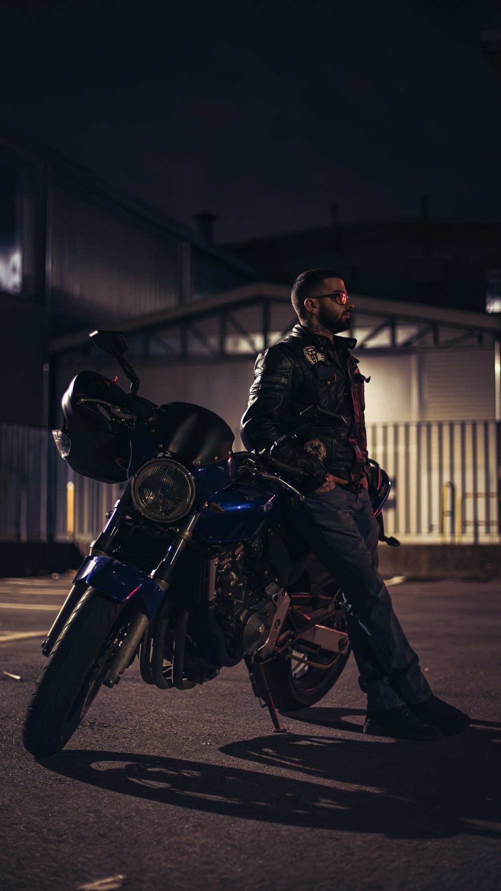 a man sitting on a motorcycle in a parking lot