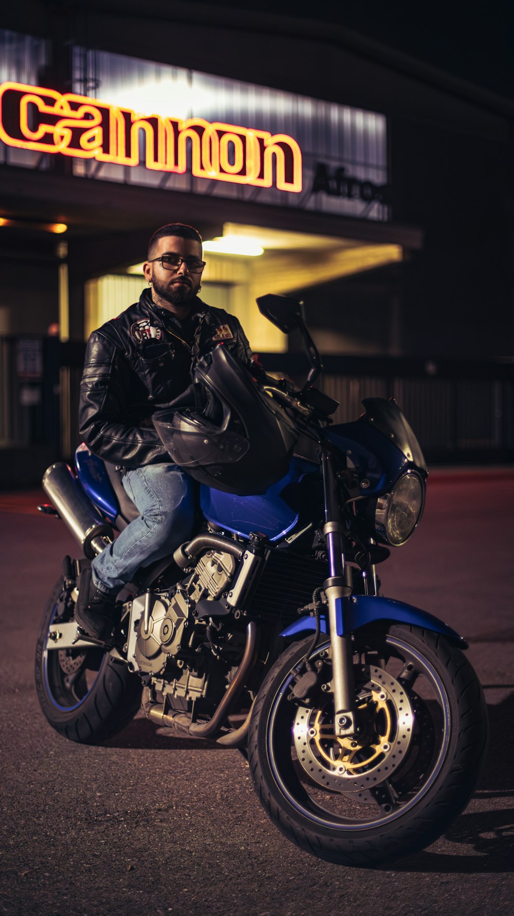 a man sitting on a motorcycle in front of a building