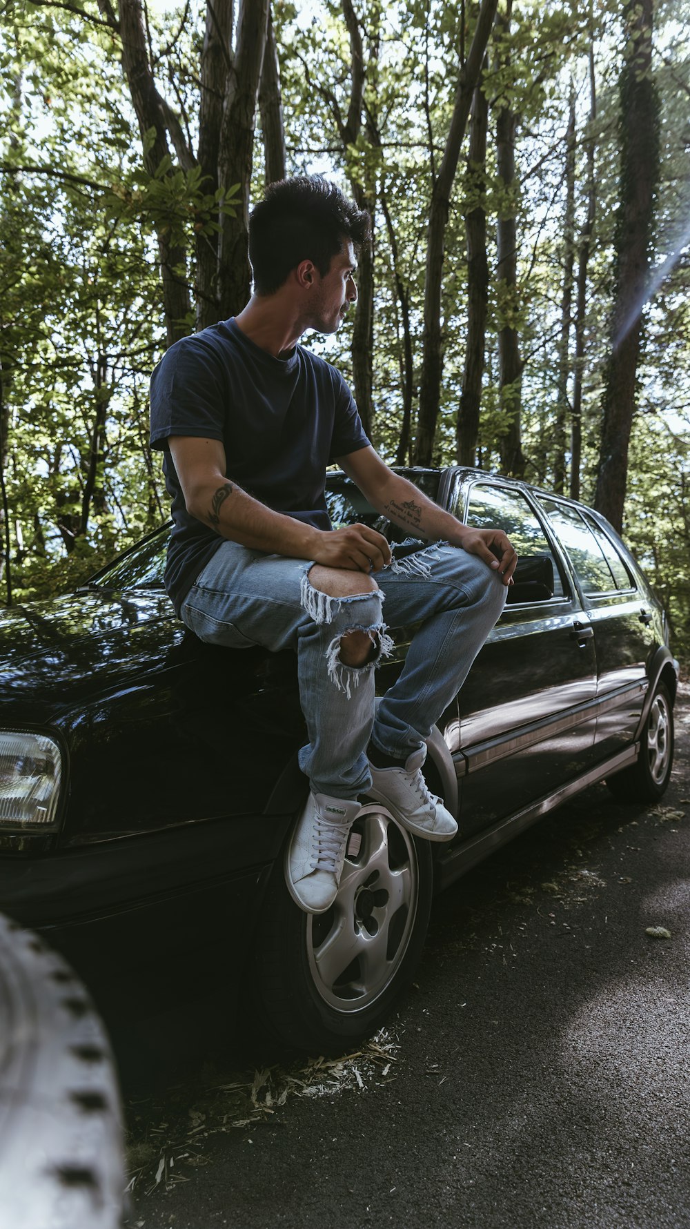 a man sitting on the hood of a car