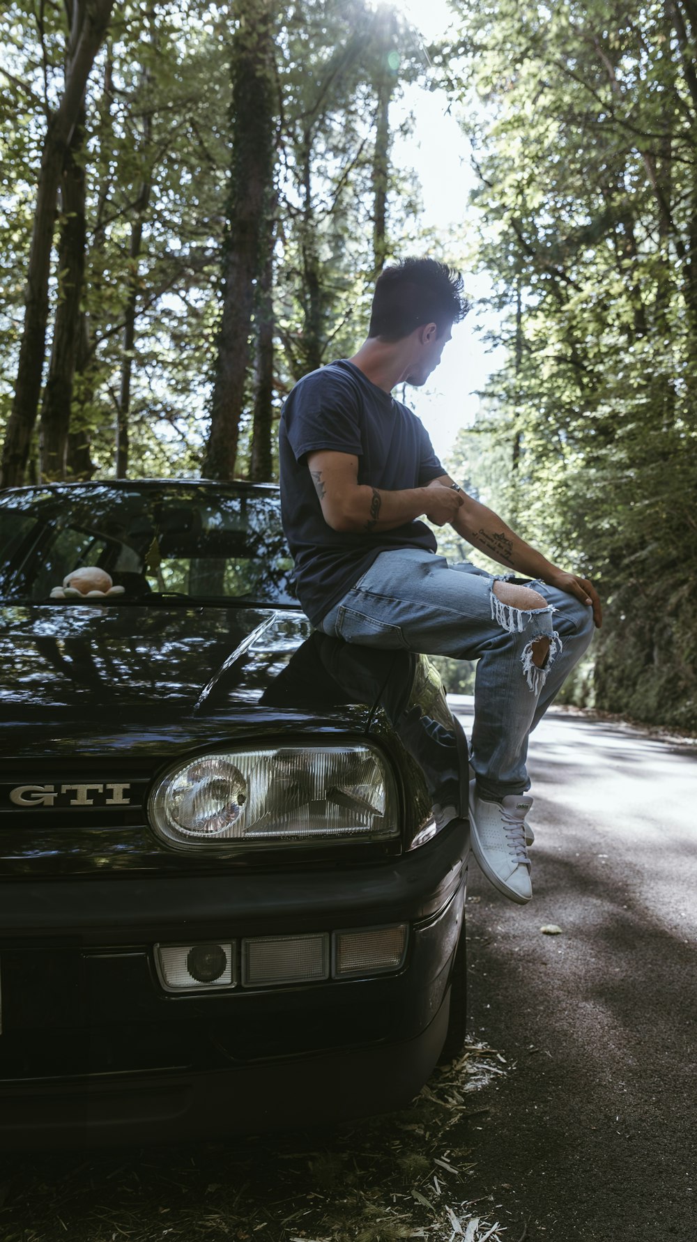 a man sitting on the hood of a car