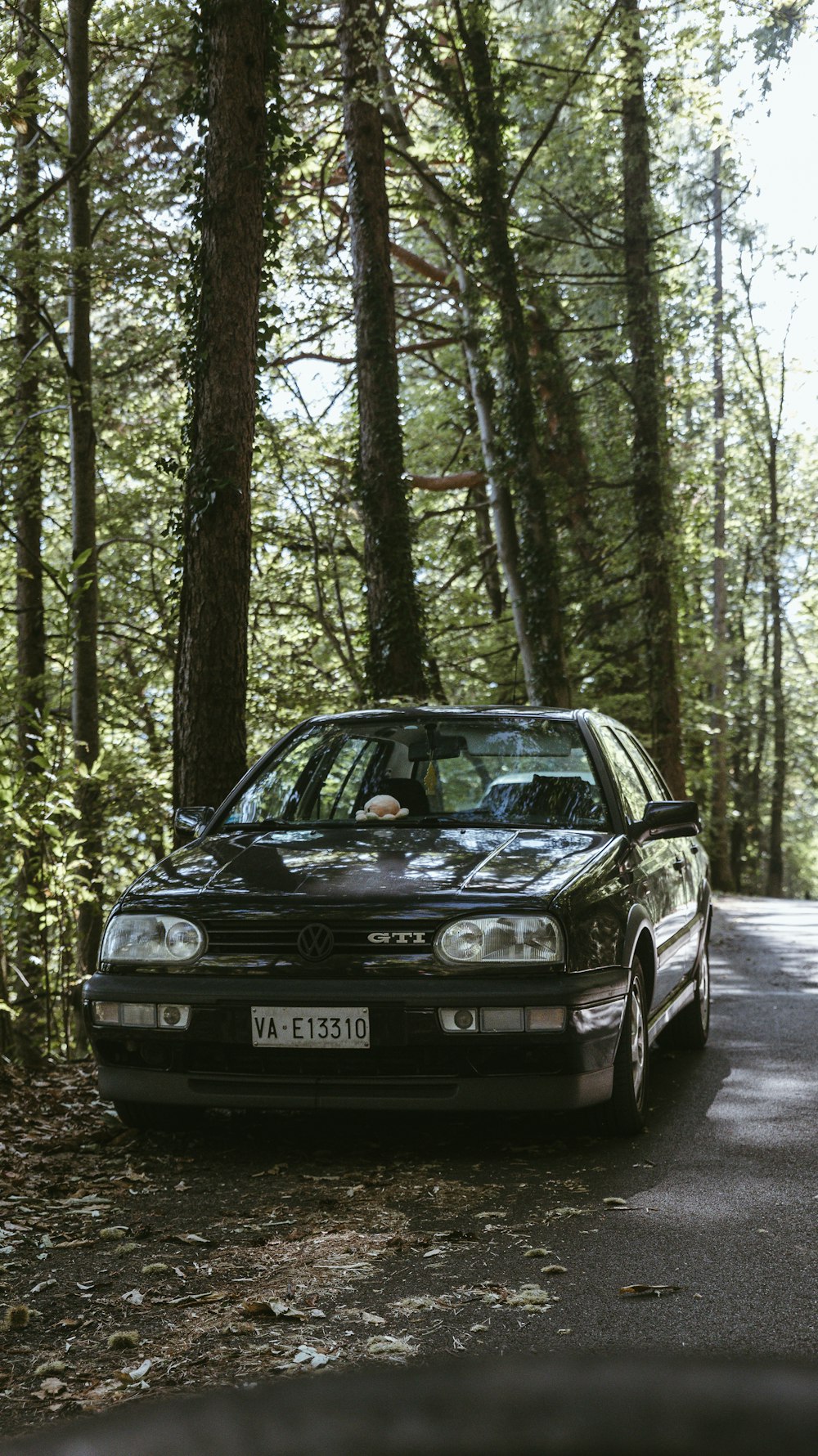 a car parked on the side of the road in the woods