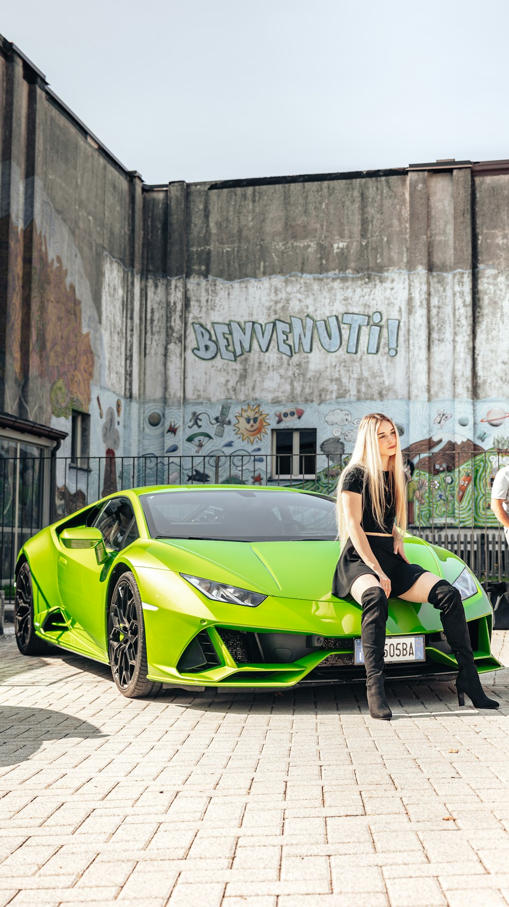 a woman sitting on top of a green sports car