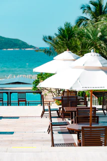 tables and chairs with umbrellas on the beach