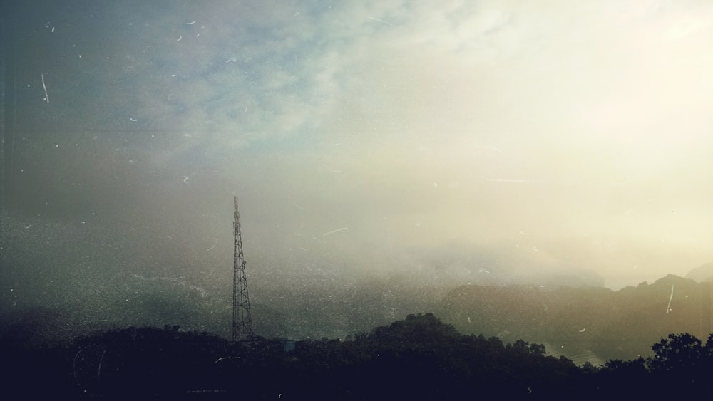 a cell phone tower in the middle of a foggy sky
