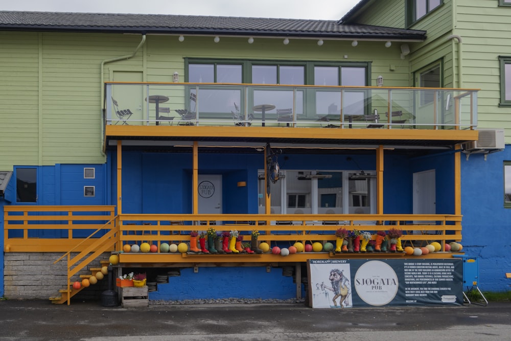 a blue and yellow building with a yellow railing
