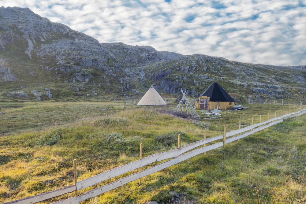 a couple of tents sitting on top of a lush green field