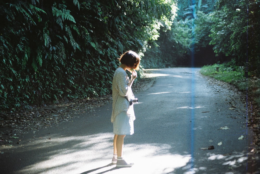 a woman standing in the middle of a road