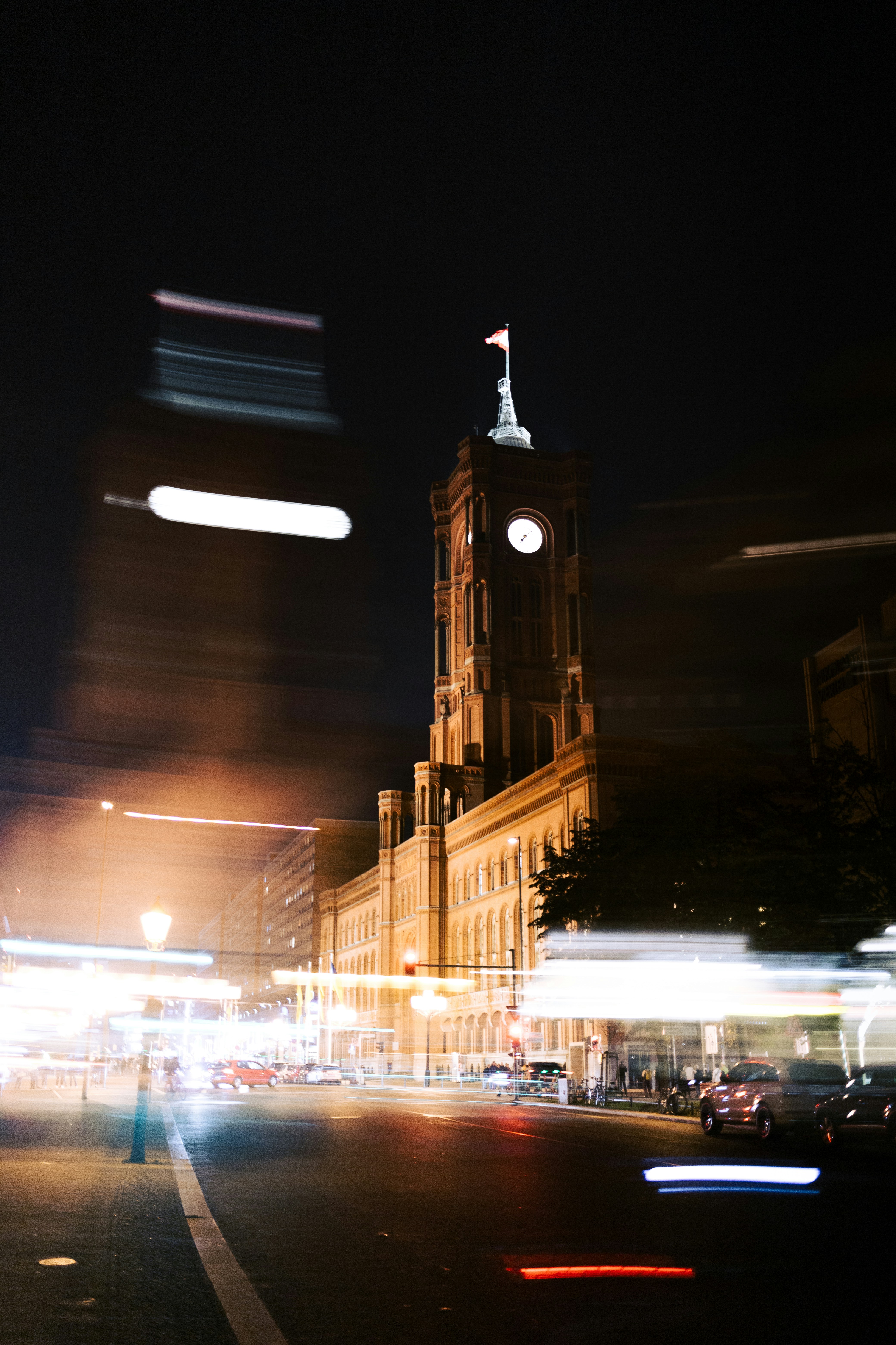 a city street at night with a clock tower in the background