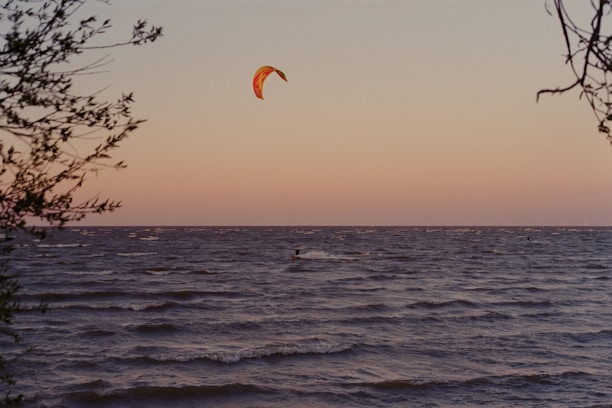 Kite surfer catching the wind above the shimmering Kalpitiya lagoon at sunset.