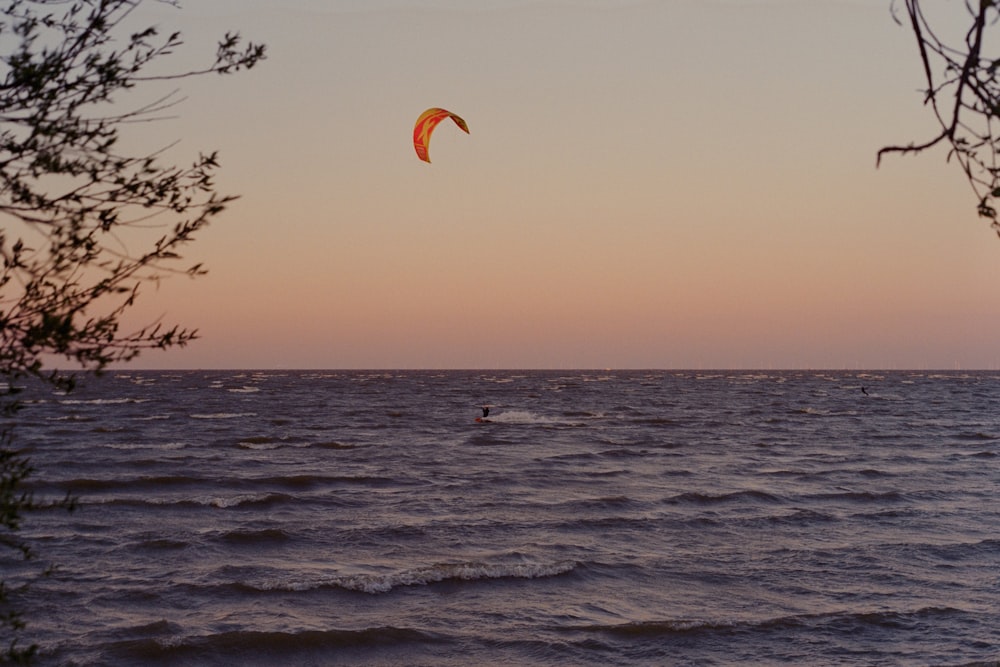 une personne para voile dans l’océan au coucher du soleil