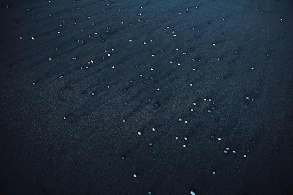 a black sand covered in tiny white dots