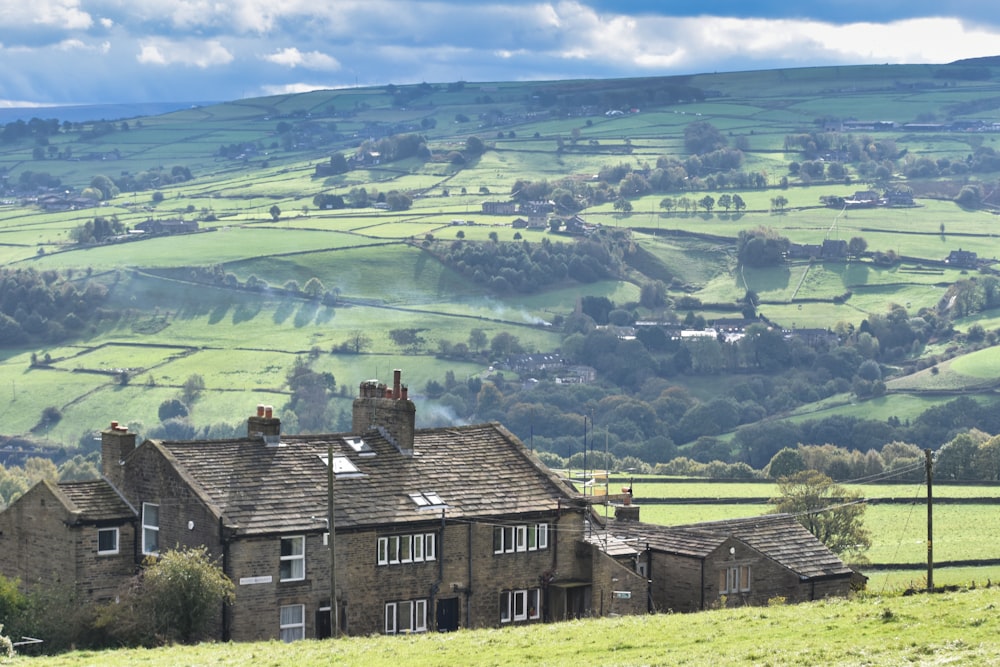 a house in the middle of a lush green field