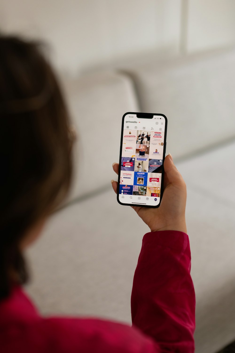 a woman holding up a cell phone with a bunch of stickers on it