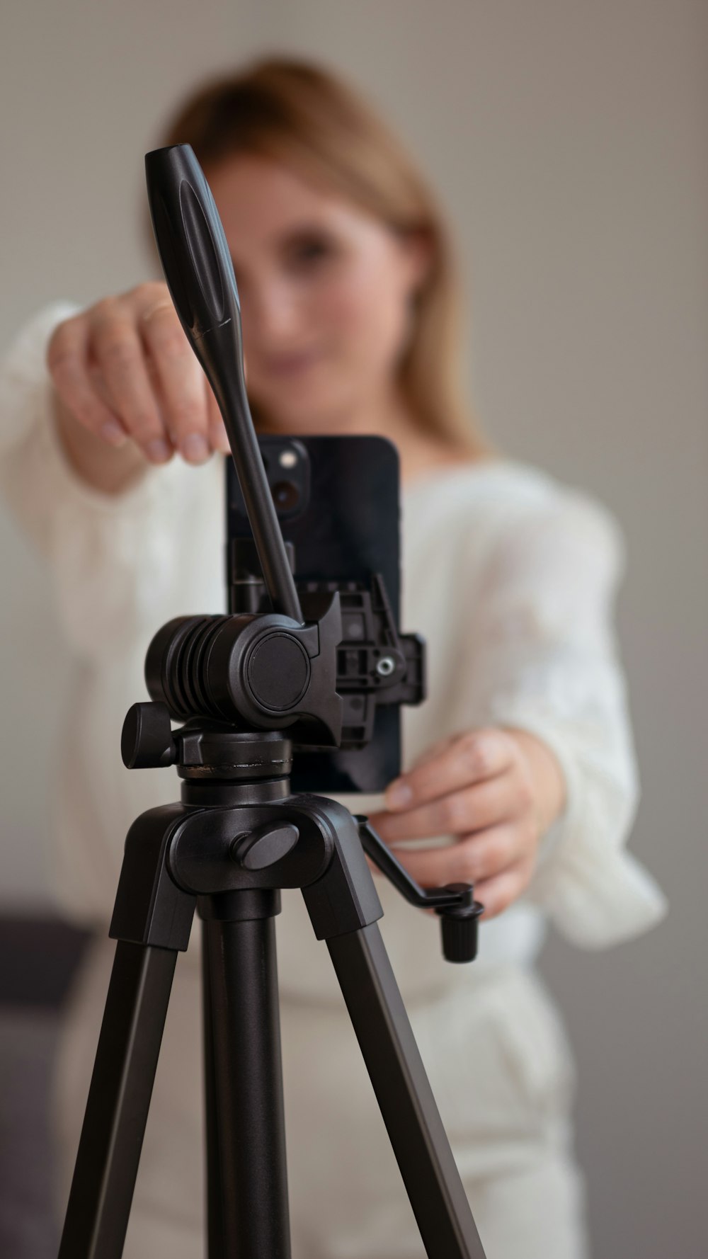 a woman taking a picture of herself on a tripod