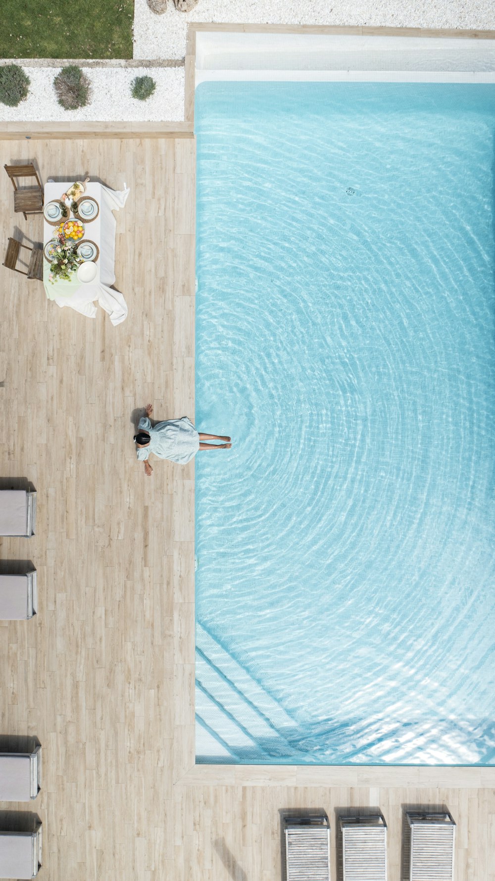 a woman standing next to a swimming pool