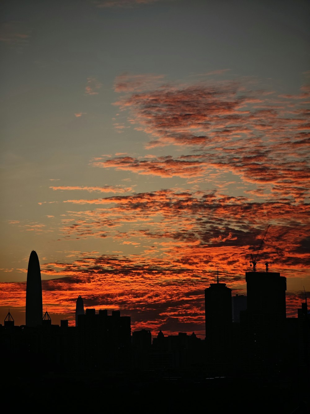 a city skyline at sunset with a red sky