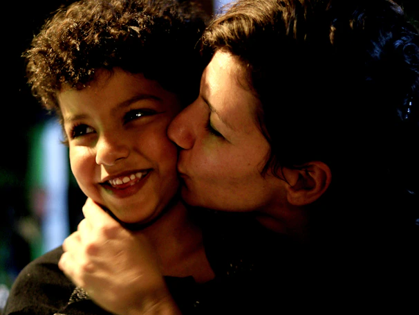 A heartfelt moment of a volunteer handing a small gift to a smiling child.