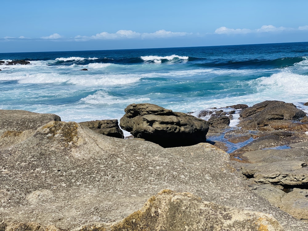 a rocky beach with waves crashing in to the shore