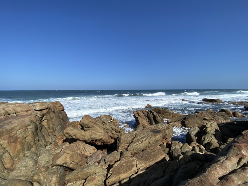 a rocky beach with waves coming in from the ocean