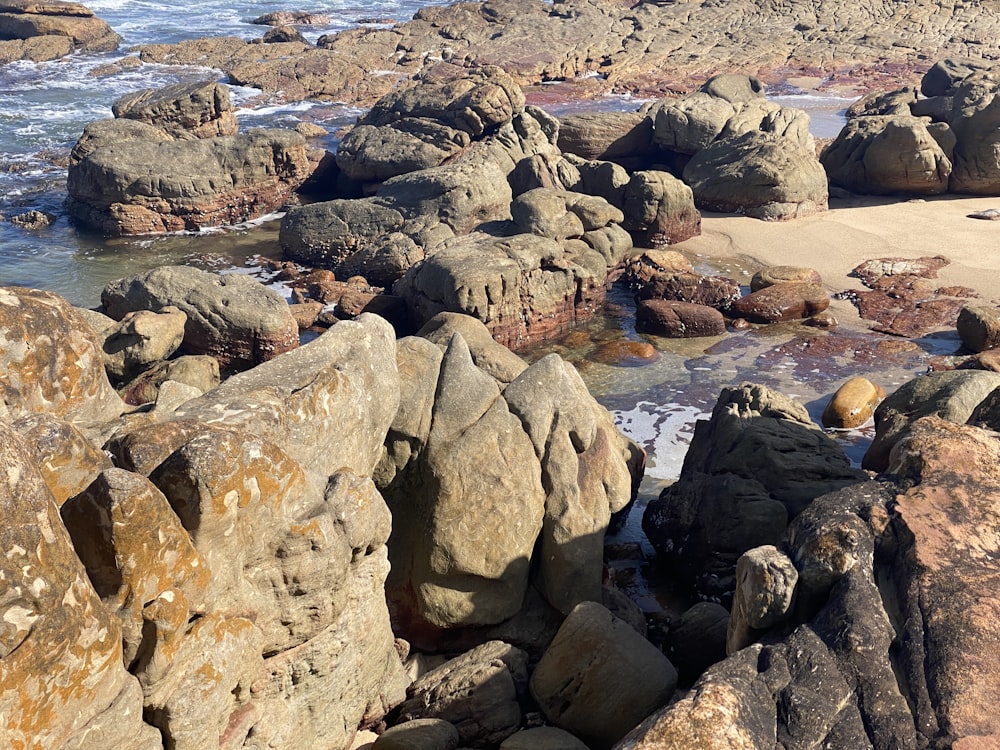 a rocky beach with rocks and a body of water