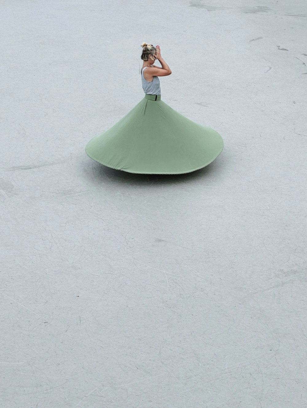 a woman in a green dress is sitting on a large object