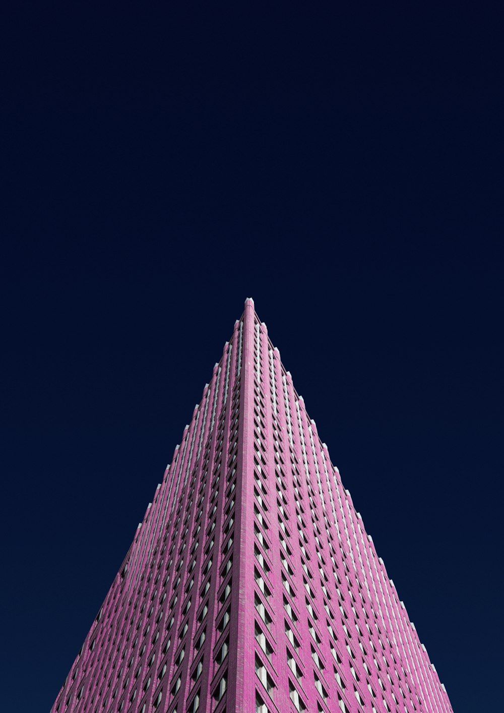 a very tall pink building with a sky background