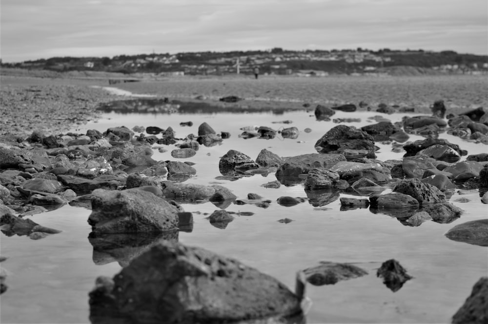 a black and white photo of rocks and water