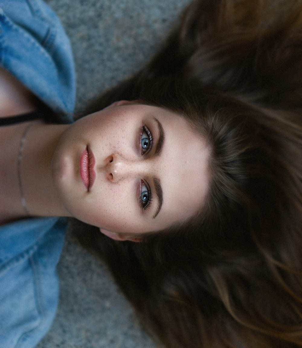 a girl with long hair laying on the ground