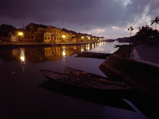 A peaceful riverside scene with traditional boats floating gently at sunset.