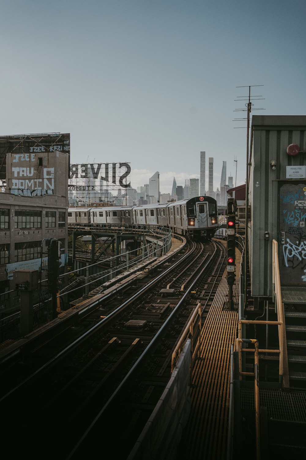 a train traveling down train tracks next to a tall building