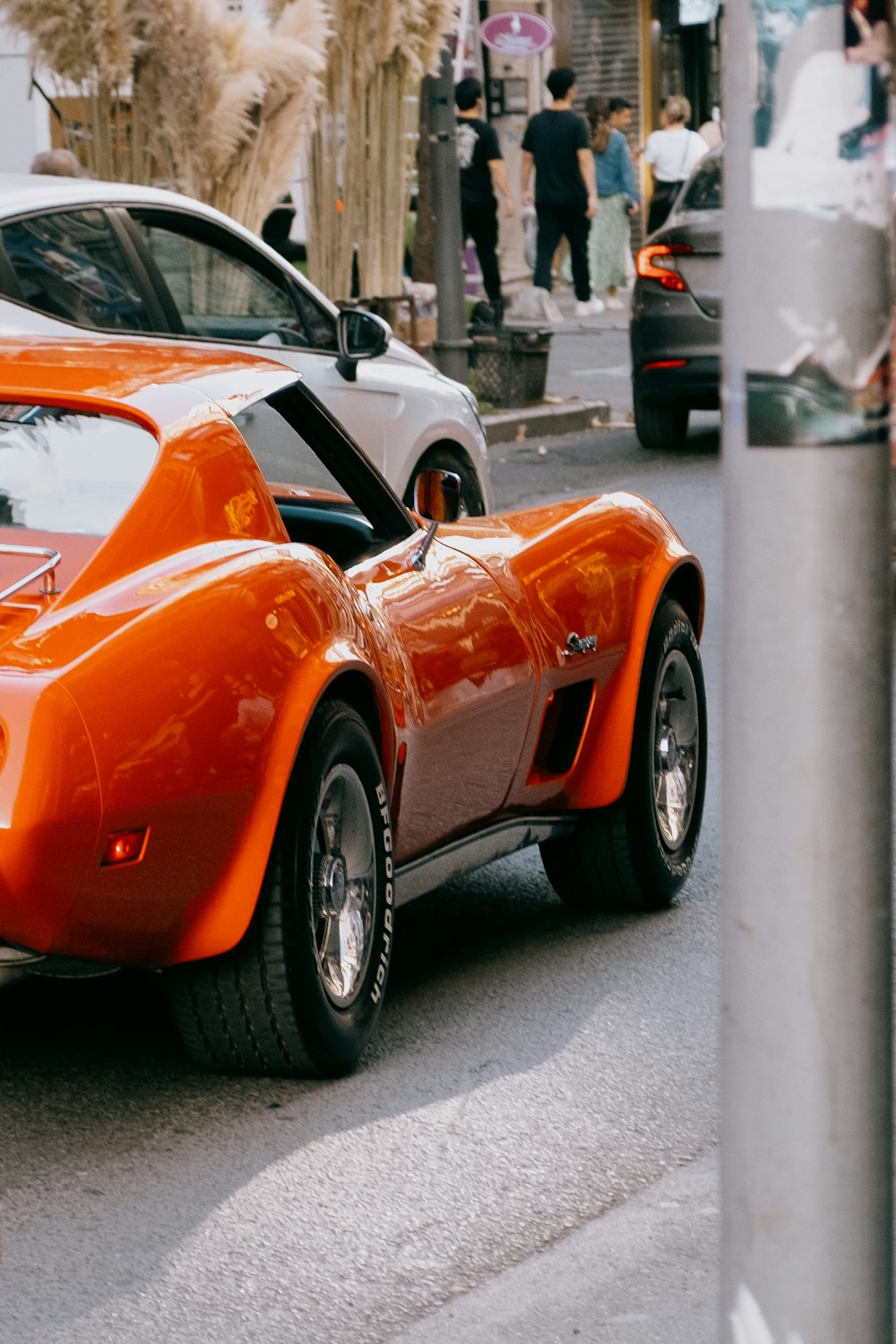 an orange sports car parked on the side of the road