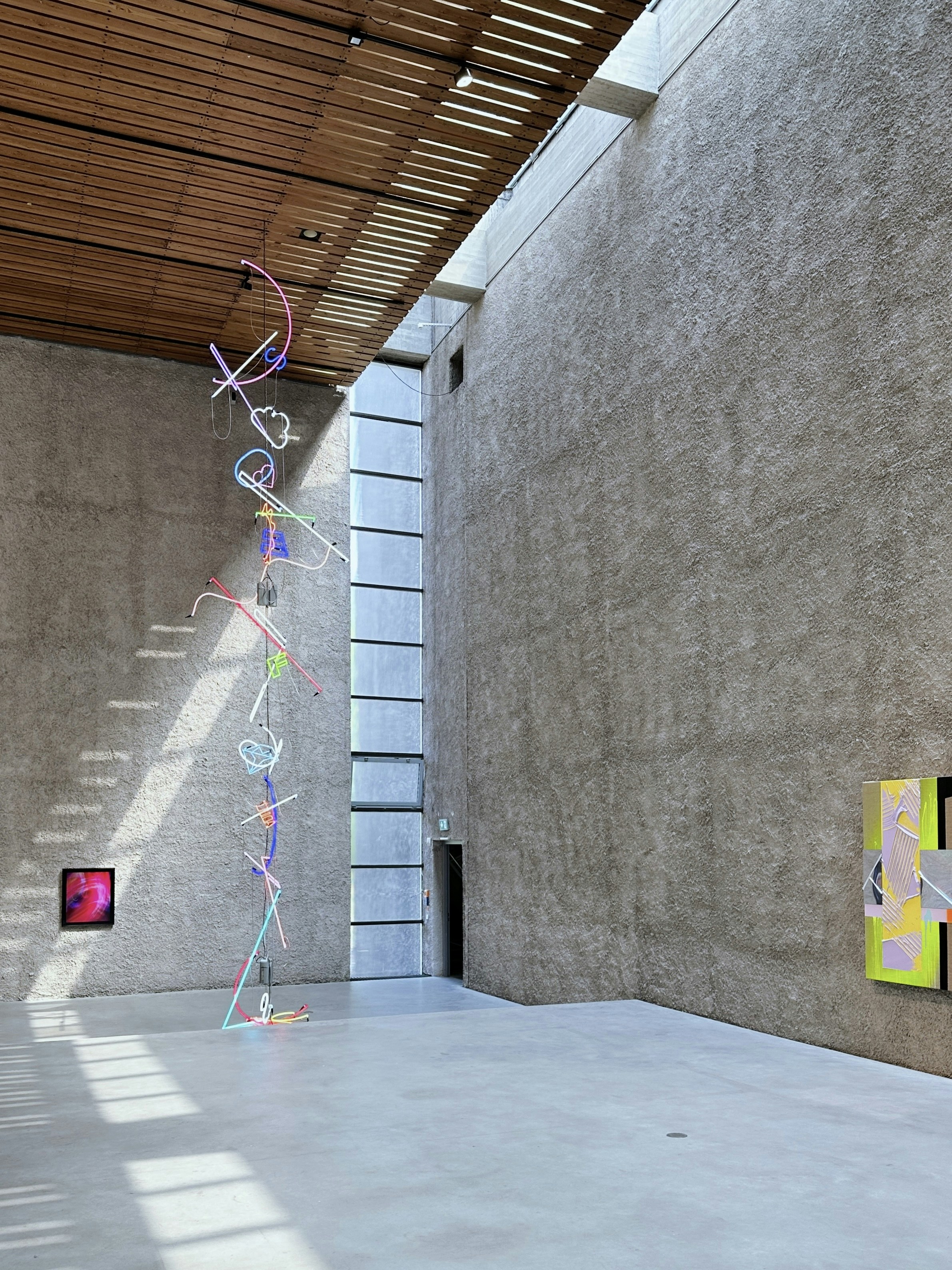 a room with a sculpture on the wall and paintings on the wall