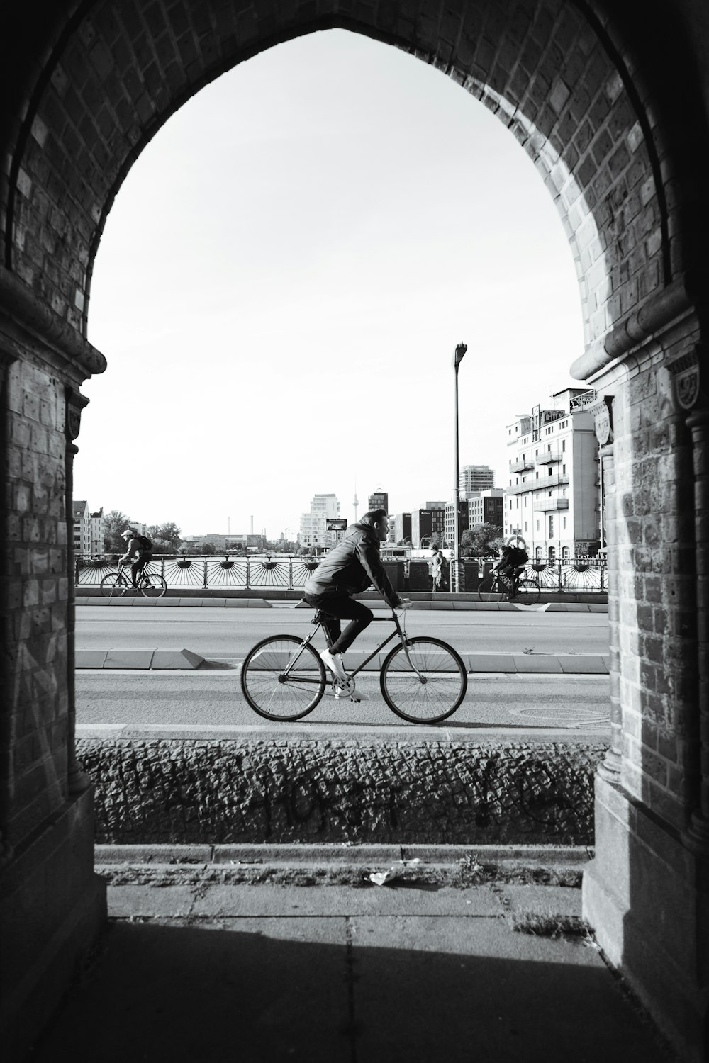 a man riding a bike through an archway