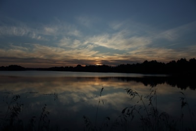 A calm lake mirroring the sky at dusk, illustrating harmony in nature.