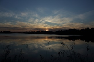 A tranquil lake reflecting the sky at dusk.