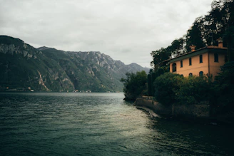 A welcoming portrait of Scott Buitta standing by a serene lakeside home in New Hampshire.