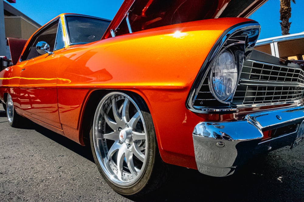 an orange classic car parked in a parking lot