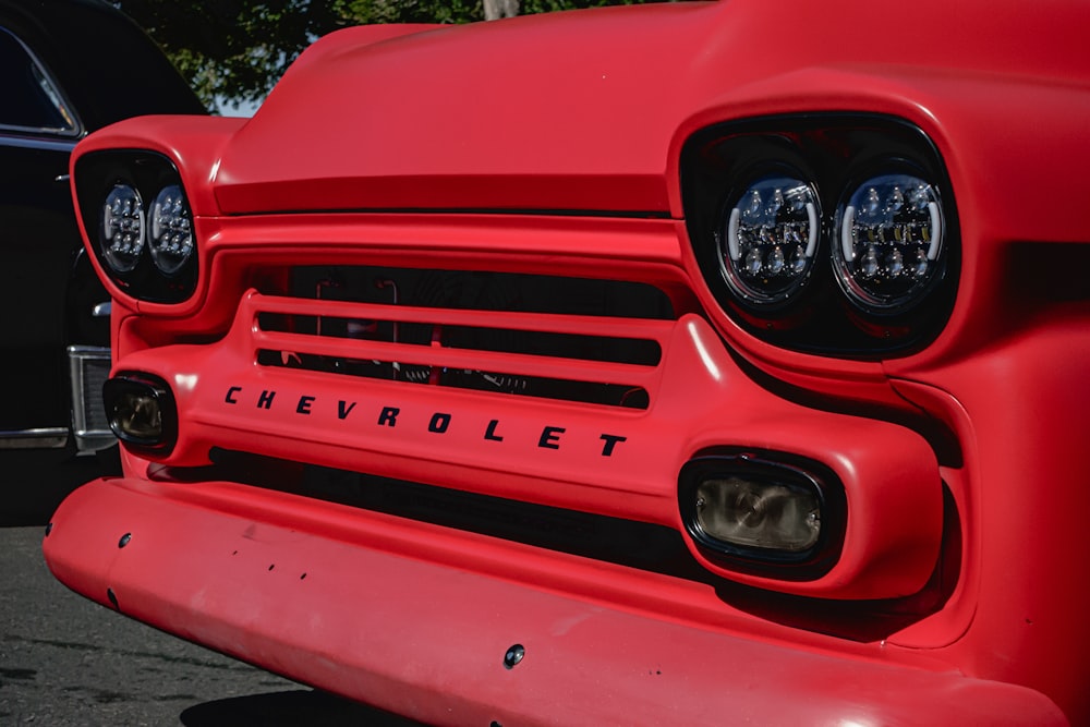 a close up of the front of a red chevrolet truck