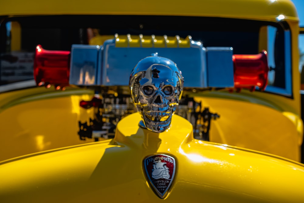 a skull head on the hood of a yellow car