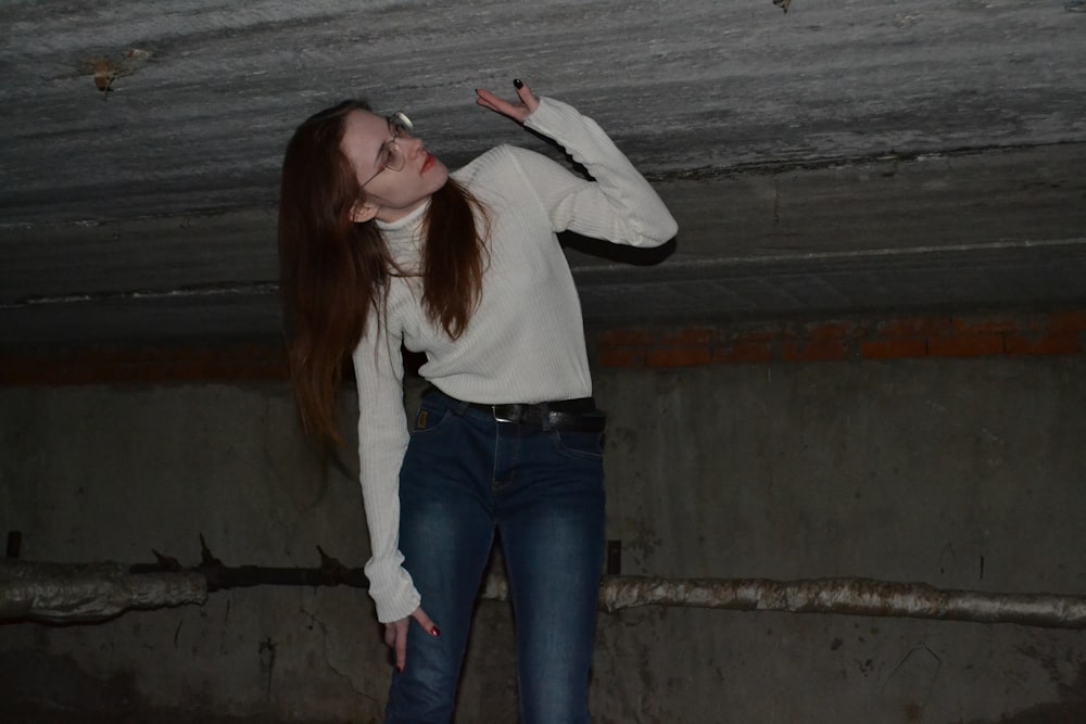 a woman in a white shirt and jeans posing for a picture